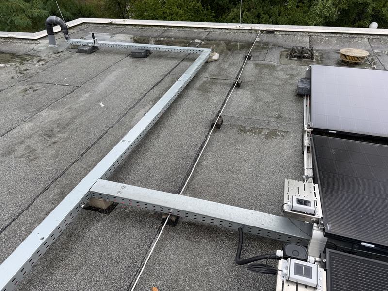 Flachdach mit montierter Unterkonstruktion aus Aluminiumschienen, rechts die ersten verlegten Module.